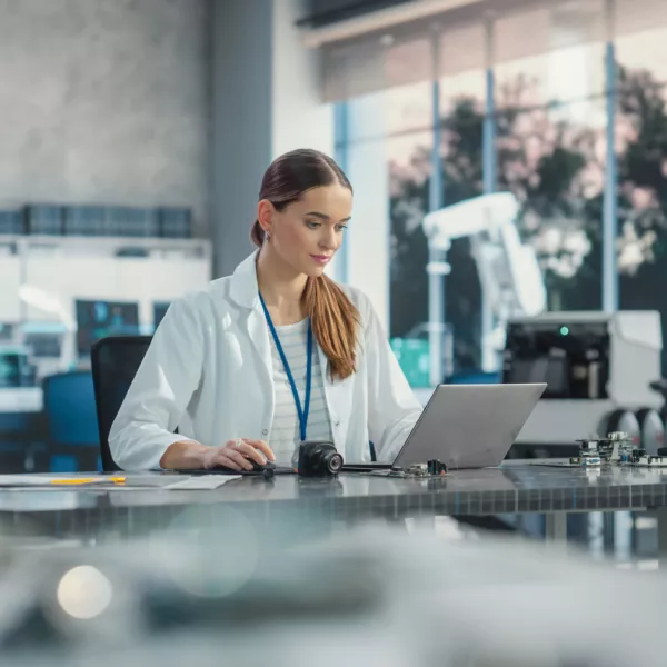 Portrait of Professional Female Scientist Working in Industrial Lab Using Laptop Computer. Successful Project Manager Making Strategy Plans for Industrial Production Company, Using Technology