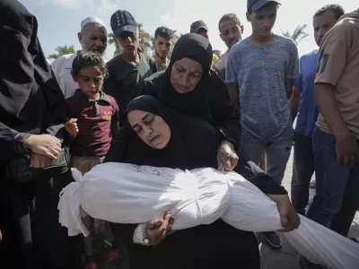 A woman holds the body of her daughter Zena Naser, killed in an Israeli bombardment on a residential building in Maghazi refugee camp, outside the morgue of al-Aqsa Martyrs Hospital in Deir al Balah, central Gaza Strip, Tuesday, June 25, 2024. (AP Photo/Abdel Kareem Hana)