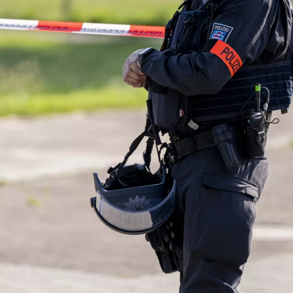 27 June 2024, Thuringia, Erfurt: A police officer stands in front of a police cordon near the suspected crime scene in Erfurt, where a man was shot dead. A large-scale police operation is currently underway. Photo: Jacob Schröter/dpa