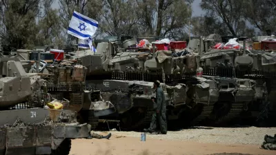 FILE PHOTO: An Israeli soldier walks near military vehicles, amid the ongoing conflict between Israel and the Palestinian Islamist group Hamas, near Israel's border with Gaza in southern Israel, May 29, 2024. REUTERS/Ronen Zvulun/File Photo