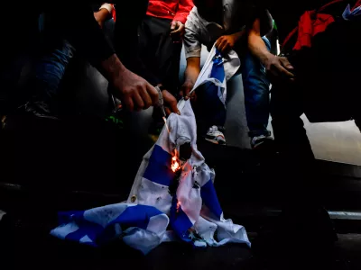 ﻿13 May 2021, Italy, Milan: Demonstrators burn an Israeli flag during a demonstration in solidarity with Palestinians amid the escalating flare-up of Israeli-Palestinian violence. Photo: Claudio Furlan/LaPresse via ZUMA Press/dpa