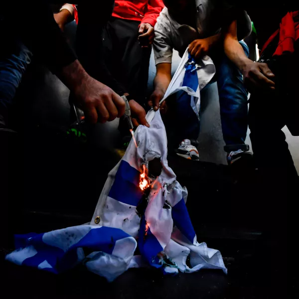 ﻿13 May 2021, Italy, Milan: Demonstrators burn an Israeli flag during a demonstration in solidarity with Palestinians amid the escalating flare-up of Israeli-Palestinian violence. Photo: Claudio Furlan/LaPresse via ZUMA Press/dpa