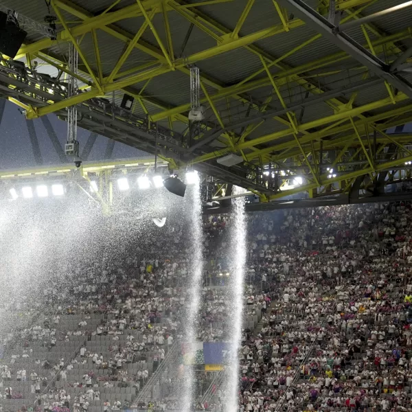 Rainwater flows from the stadium roof at a Round of 16 match between Germany and Denmark at the Euro 2024 soccer championship Saturday, June 29, 2024, in Dortmund, Germany. (Marcus Brandt/dpa via AP)