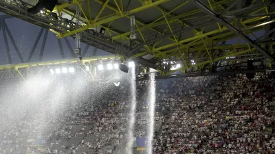 Rainwater flows from the stadium roof at a Round of 16 match between Germany and Denmark at the Euro 2024 soccer championship Saturday, June 29, 2024, in Dortmund, Germany. (Marcus Brandt/dpa via AP)