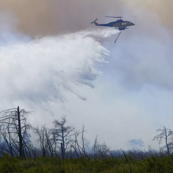 29 June 2024, Greece, Athens: A helicopter drops water to extinguish a large wildfire in the mountain of Parnitha. Photo: Nikolas Georgiou/ZUMA Press Wire/dpa