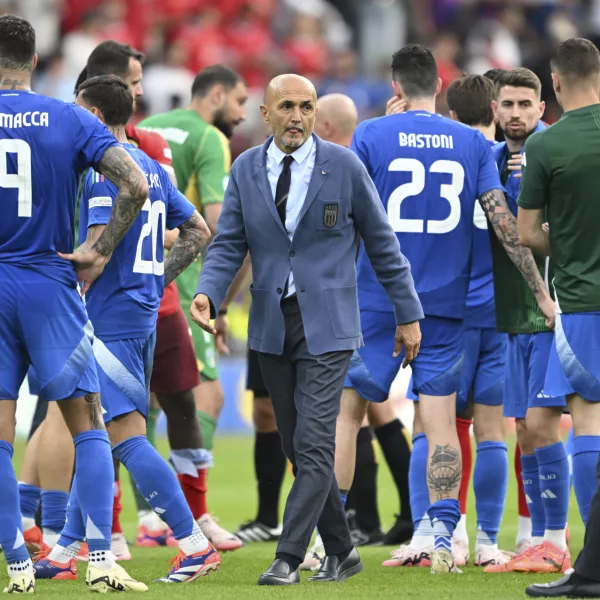 Italy's coach Luciano Spalletti, center, walks between his players after a round of sixteen match between Switzerland and Italy at the Euro 2024 soccer tournament in Berlin, Germany, Saturday, June 29, 2024. (Robert Michael/dpa via AP)