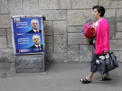 A woman walk past posters depicting Vojislav Seselj, the leader of the ultra-nationalist SRS-Serbian Radical Party, reading: "Radical consistently! For free Serbia", in Belgrade, Serbia, Friday, April 13, 2012. Vojislav Seselj's wife Jadranka will be Serb Radical Party candidate in the presidential election on May 6. (AP Photo/Darko Vojinovic)