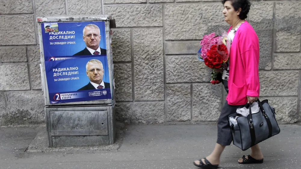 A woman walk past posters depicting Vojislav Seselj, the leader of the ultra-nationalist SRS-Serbian Radical Party, reading: "Radical consistently! For free Serbia", in Belgrade, Serbia, Friday, April 13, 2012. Vojislav Seselj's wife Jadranka will be Serb Radical Party candidate in the presidential election on May 6. (AP Photo/Darko Vojinovic)