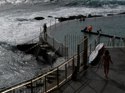 Members of the public are seen at the Bronte Baths in Sydney, Friday, October 7, 2022. More than a dozen rivers are flooding across NSW as a cloud band brings continued heavy falls and storms across NSW. (AAP Image/Bianca De Marchi) NO ARCHIVING