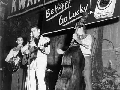 SHREVEPORT, LA - OCTOBER 16: Singer Elvis Presley joins his guitar player Scotty Moore (left) and bass player Bill Black on a weekly broadcast of "Lousiana Hayride" at the Shreveport Auditorium just three months after Elvis left home for the first time on October 16, 1954 in Shreveport, Lousiana. (Photo by Michael Ochs Archives/Getty Images)