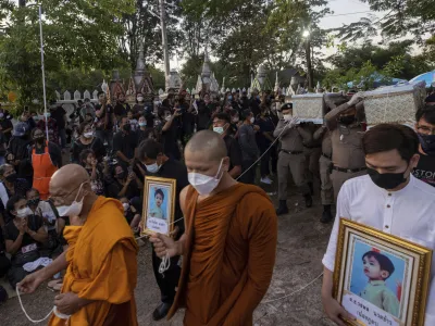 Police carry a coffin containing a victim of the day care center attack for cremation at Wat Rat Samakee temple in Uthai Sawan, northeastern Thailand, Tuesday, Oct. 11, 2022. A former police officer burst into a day care center in northeastern Thailand on Thursday, killing dozens of preschoolers and teachers before shooting more people as he fled. (AP Photo/Wason Wanichakorn)