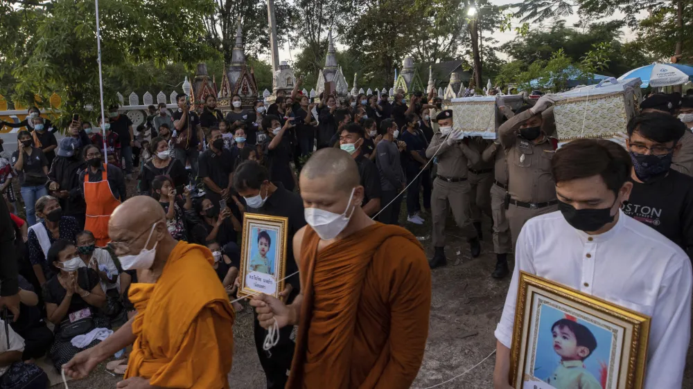 Police carry a coffin containing a victim of the day care center attack for cremation at Wat Rat Samakee temple in Uthai Sawan, northeastern Thailand, Tuesday, Oct. 11, 2022. A former police officer burst into a day care center in northeastern Thailand on Thursday, killing dozens of preschoolers and teachers before shooting more people as he fled. (AP Photo/Wason Wanichakorn)