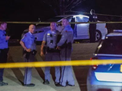 Law enforcement officers work a crime scene in the Hedingham neighborhood and Neuse River Trail area in Raleigh, N.C., after five people were shot and killed Thursday, Oct. 13, 2022. (Travis Long/The News & Observer via AP)