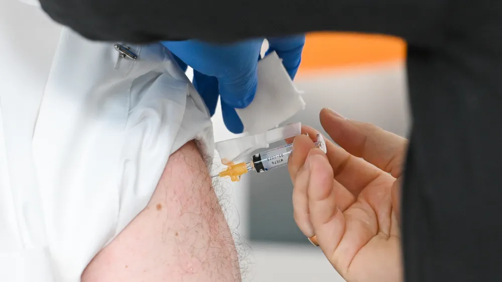 11 October 2022, Bavaria, Munich: A man receives an influenza vaccination at the Bavarian State Chancellery. Photo: Tobias Hase/dpa