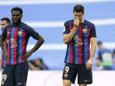 Barcelona's Robert Lewandowski, right, and Franck Kessie react during a Spanish La Liga soccer match between Real Madrid and Barcelona at the Santiago Bernabeu stadium in Madrid, Sunday, Oct. 16, 2022. (AP Photo/Manu Fernandez)