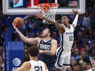 Oct 22, 2022; Dallas, Texas, USA; Dallas Mavericks guard Luka Doncic (77) shoots as Memphis Grizzlies guard Ja Morant (12) defends during the second half at American Airlines Center. Mandatory Credit: Kevin Jairaj-USA TODAY Sports