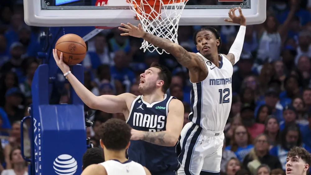 Oct 22, 2022; Dallas, Texas, USA; Dallas Mavericks guard Luka Doncic (77) shoots as Memphis Grizzlies guard Ja Morant (12) defends during the second half at American Airlines Center. Mandatory Credit: Kevin Jairaj-USA TODAY Sports