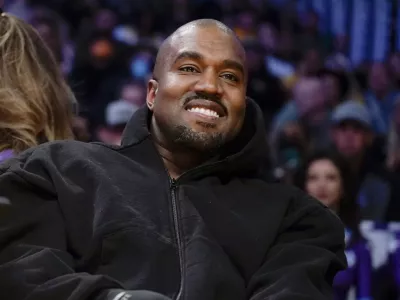 FILE - Kanye West watches the first half of an NBA basketball game between the Washington Wizards and the Los Angeles Lakers in Los Angeles, on March 11, 2022. Former President Donald Trump had dinner Tuesday, Nov. 22, at his Mar-a-Lago club with the rapper formerly known as Kanye West, who is now known as Ye, as well as Nick Fuentes, a far-right activist who has used his online platform to spew antisemitic and white supremacist rhetoric. (AP Photo/Ashley Landis, File)