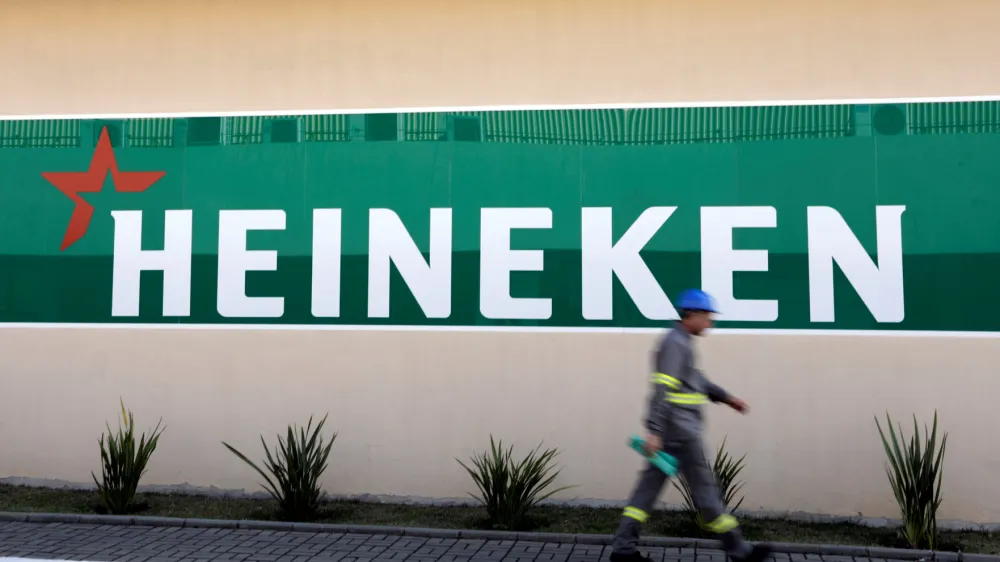 ﻿FILE PHOTO: An employee walks past the logo of Heineken at the Heineken brewery in Jacarei, Brazil June 12, 2018. REUTERS/Paulo Whitaker/File Photo