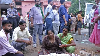 Women mourn next to the body of a relative outside the Sikandrarao hospital in Hathras district about 350 kilometers (217 miles) southwest of Lucknow, India, Tuesday, July 2, 2024. At least 60 people are dead and scores are injured after a stampede at a religious gathering of thousands of people in northern India, officials said Tuesday.(AP Photo/Manoj Aligadi)