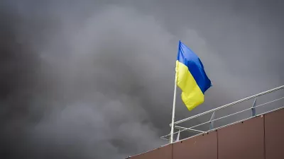 In this photo released by the Dnipro Regional Administration, Ukrainian flag waves as smoke rises after Russia's missile attack in Dnipro, Ukraine, Wednesday, July 3, 2024. (Dnipro Regional Administration via AP)