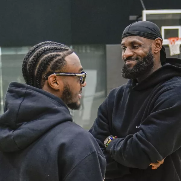 Los Angeles Lakers draft pick Bronny James, left, and his father, LeBron James, share a light moment as they arrive for the NBA basketball team's news conference in El Segundo, Calif., Tuesday, July 2, 2024 (AP Photo/Damian Dovarganes)