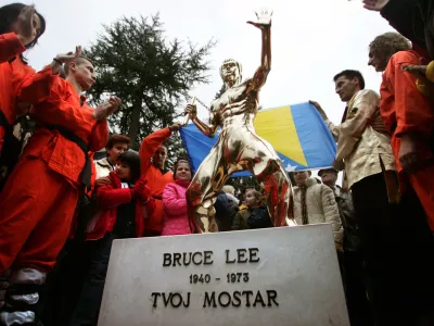 Bosnian Kung Fu practitioners applaud a newly unveiled bronze statue of Bruce Lee, a Chinese-American martial arts master in a typical fighting pose during a ceremony in Mostar November 26, 2005. A new symbol of unity was erected on Saturday in the ethnically divided Bosnian city of Mostar - a statue of Kung Fu legend Bruce Lee, worshipped by Muslims, Serbs and Croats. A group of enthusiasts in Mostar, the scene of fighting between Muslims and Croats in 1993-1994, agreed they needed a symbol of justice, mastery and honesty - virtues upheld by the late Chinese-American actor.  REUTERS/Damir Sagolj