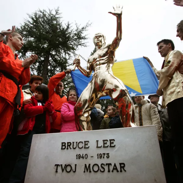 Bosnian Kung Fu practitioners applaud a newly unveiled bronze statue of Bruce Lee, a Chinese-American martial arts master in a typical fighting pose during a ceremony in Mostar November 26, 2005. A new symbol of unity was erected on Saturday in the ethnically divided Bosnian city of Mostar - a statue of Kung Fu legend Bruce Lee, worshipped by Muslims, Serbs and Croats. A group of enthusiasts in Mostar, the scene of fighting between Muslims and Croats in 1993-1994, agreed they needed a symbol of justice, mastery and honesty - virtues upheld by the late Chinese-American actor.  REUTERS/Damir Sagolj