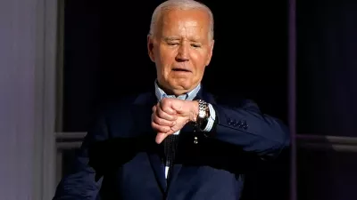 U.S. President Joe Biden looks at his watch as he stands on the balcony during an Independence Day celebration on the South Lawn of the White House in Washington, U.S., July 4, 2024. REUTERS/Elizabeth Frantz