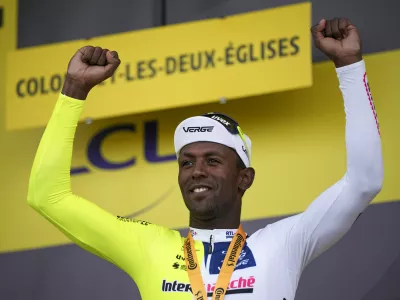 Stage winner Eritrea's Biniam Girmay celebrates on the podium after the eighth stage of the Tour de France cycling race over 183.4 kilometers (114 miles) with start in Semur-en-Auxois and finish in Colombey-les-Deux-Eglises, France, Saturday, July 6, 2024. (AP Photo/Daniel Cole)