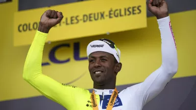 Stage winner Eritrea's Biniam Girmay celebrates on the podium after the eighth stage of the Tour de France cycling race over 183.4 kilometers (114 miles) with start in Semur-en-Auxois and finish in Colombey-les-Deux-Eglises, France, Saturday, July 6, 2024. (AP Photo/Daniel Cole)