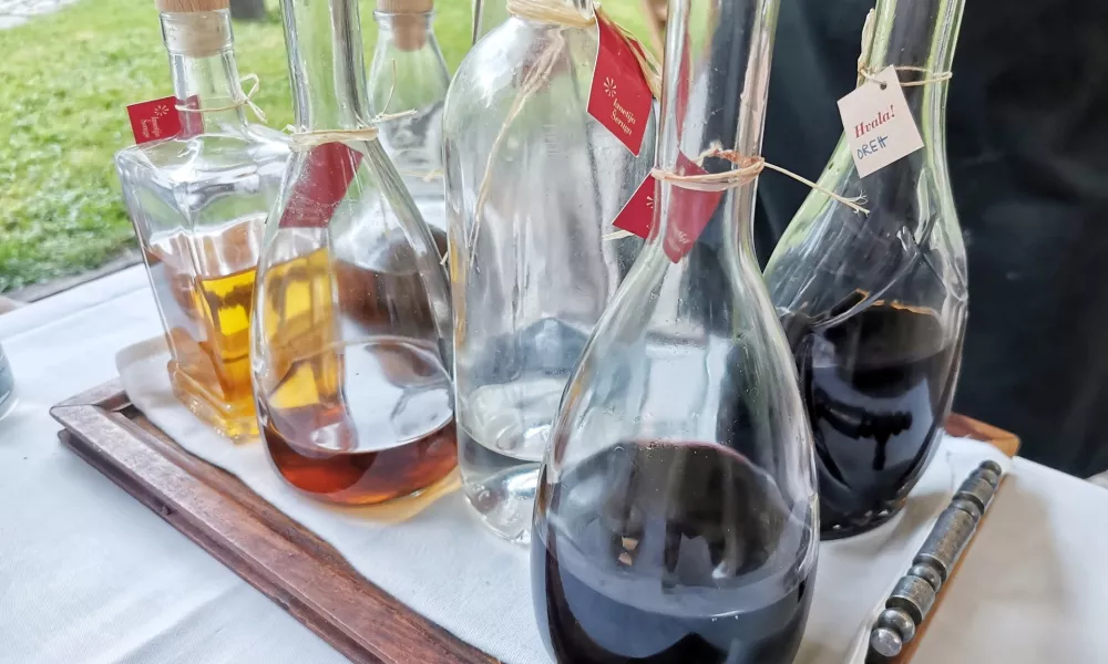 Osem steklenic različnega žganja. / Foto: Miha First