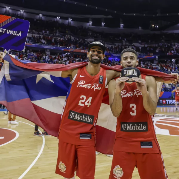 Puerto Rico's Jordan Howard, right, and Gian Clavell celebrate after their team qualified for the Paris 2024 Olympics, after eliminating Lithuania in a FIBA Olympic Qualifying basketball final in San Juan, Puerto Rico, Sunday, July 7, 2024. (AP Photo/Alejandro Granadillo)