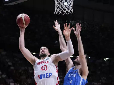 Croatia's Ivica Zubac, left, jumps to score against Greece's Georgia's Papagiannis, right,during a during a FIBA Olympic Qualifying basketball final, at the Peace and Friendship stadium at Athens' port city of Piraeus, Sunday, July 7, 2024. (AP Photo/Petros Giannakouris)