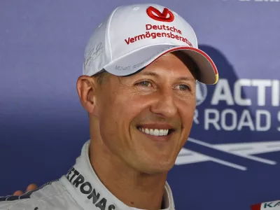 Mercedes Formula 1 car driver Michael Schumacher who finished third following the qualifying session poses for the photographers at the Silverstone circuit, England, Saturday, July 7, 2012. Ferrari Formula 1 car driver Fernando Alonso, of Spain, finished first and will start from the pole position and Red Bull Formula 1 car driver Mark Webber, of Australia finished second. The Formula 1 British Grand Prix will be held at Silverstone circuit on Sunday. (AP Photo/Lefteris Pitarakis)