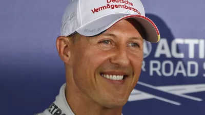 Mercedes Formula 1 car driver Michael Schumacher who finished third following the qualifying session poses for the photographers at the Silverstone circuit, England, Saturday, July 7, 2012. Ferrari Formula 1 car driver Fernando Alonso, of Spain, finished first and will start from the pole position and Red Bull Formula 1 car driver Mark Webber, of Australia finished second. The Formula 1 British Grand Prix will be held at Silverstone circuit on Sunday. (AP Photo/Lefteris Pitarakis)