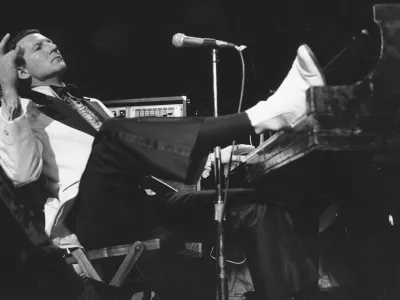 FILE - Jerry Lee Lewis props his foot on the piano as he lays back and acknowledges the applause of fans during the fifth annual Rock 'n' Roll Revival at New York's Madison Square Garden on March 14, 1975. Spokesperson Zach Furman said Lewis died Friday morning, Oct. 28, 2022, at his home in Memphis, Tenn. He was 87. (AP Photo/Rene Perez, File)