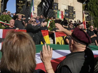 People perform a roman salute in the hometown of former dictator Benito Mussolini to mark the 100th anniversary of the coup d'etat by which he sized power in 1922, in Predappio, Italy, Sunday, Oct. 30, 2022. (AP Photo/Luca Bruno)