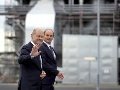 German Chancellor Olaf Scholz, left, is accompanied by the CEO of BASF, Martin Brudermueller, right, as he arrives for a visit of the BASF company in Schwarzheide south of Berlin, Germany, Tuesday, Nov. 1, 2022. (AP Photo/Michael Sohn)