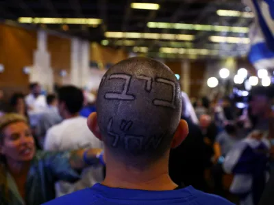 A sign reading "Bibi", nickname of Likud party leader Benjamin Netanyahu, is seen on a supporter's head, following the announcement of exit polls in Israel's general election, at the party headquarters in Jerusalem November 2, 2022. REUTERS/Ronen Zvulun