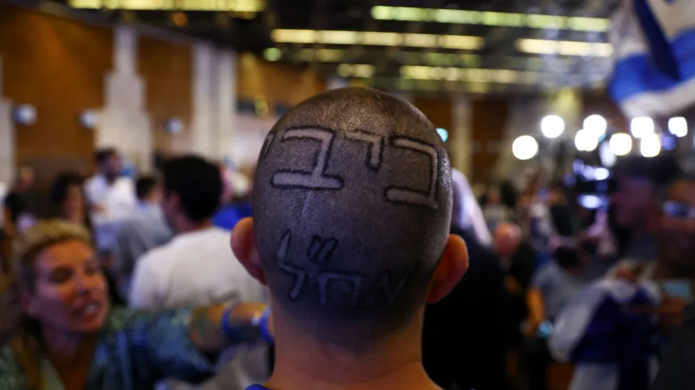 A sign reading "Bibi", nickname of Likud party leader Benjamin Netanyahu, is seen on a supporter's head, following the announcement of exit polls in Israel's general election, at the party headquarters in Jerusalem November 2, 2022. REUTERS/Ronen Zvulun