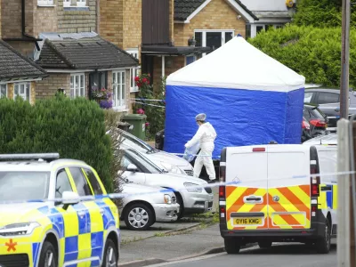 A forensic officer at the scene in Ashlyn Close, Bushey, after an incident on Tuesday evening, in Hertfordshire, England, Wednesday, July 10, 2024. British police were hunting for a man believed to be armed with a crossbow after three women were killed in a house near London. Hertfordshire Police said Kyle Clifford, 26, was being sought over the suspected triple murder. (Jacob King/PA via AP)