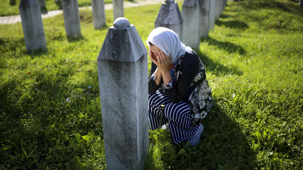 A Bosnian Muslim woman mourns next to the grave of her relative, victim of the Srebrenica genocide, at the Srebrenica Memorial Centre, in Potocari, Bosnia, Thursday, July 11, 2024. Thousands gathered in the eastern Bosnian town of Srebrenica to commemorate the 29th anniversary on Monday of Europe's only acknowledged genocide since World War II. (AP Photo/Armin Durgut)