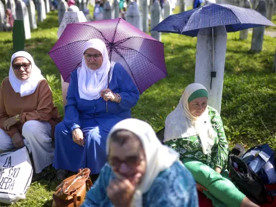 Bosnian muslim women wait for the mass burial ceremony, at the Srebrenica Memorial Centre, in Potocari, Bosnia, Thursday, July 11, 2024. Thousands gather in the eastern Bosnian town of Srebrenica to commemorate the 29th anniversary on Monday of Europe's only acknowledged genocide since World War II. (AP Photo/Armin Durgut)