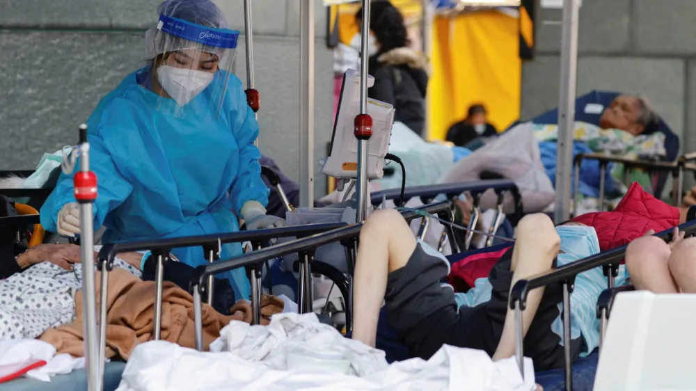 ﻿A medical worker wearing personal protective equipment (PPE) works at a makeshift coronavirus disease (COVID-19) treatment area, outside a hospital in Hong Kong, China, February 27, 2022. REUTERS/Tyrone Siu