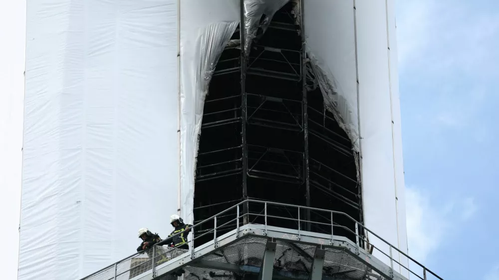 French firefighters work on the scaffolding installed for renovation works around the spire of the Notre-Dame de Rouen Cathedral after it caught fire, in Rouen, France, July 11, 2024. REUTERS/Kevin Coombs