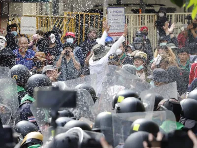 Protesters throw fermented fish sauce to riot police during a protest against the Asia-Pacific Economic Cooperation (APEC) forum, Friday, Nov. 18, 2022, in Bangkok Thailand. (AP Photo/Sarot Meksophawannakul)