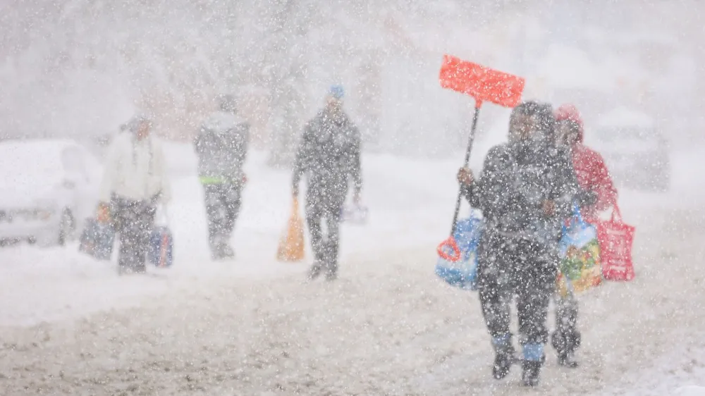 Residents walk on the street during a snowstorm as extreme winter weather hits Buffalo, New York, U.S., November 18, 2022. REUTERS/Lindsay DeDario