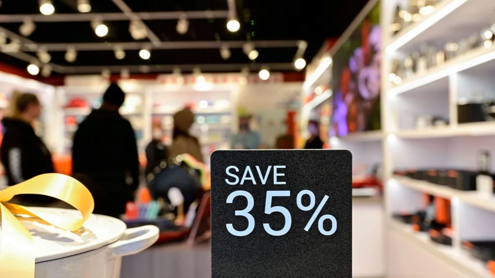 FILE PHOTO: People walk around a shop while a discount sign is seen outside as Black Friday sales begin at The Outlet Shoppes of the Bluegrass in Simpsonville, Kentucky, U.S., November 26, 2021. REUTERS/Jon Cherry/File Photo