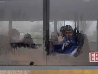 A boy waves as he leaves on an evacuation bus, after Russia's military retreat from Kherson, at the central bus station in Kherson, Ukraine November 24, 2022. REUTERS/Murad Sezer   TPX IMAGES OF THE DAY